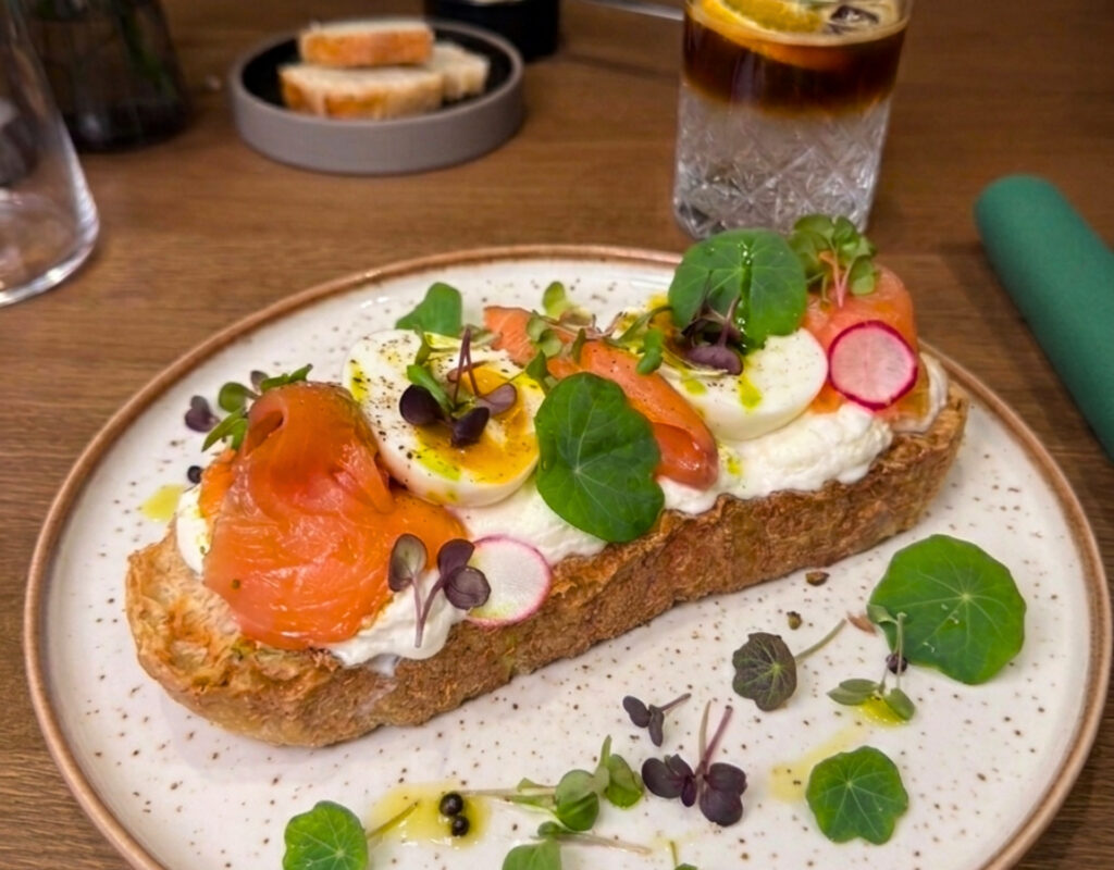 Tost z łososiem, jajkiem i serkiem na talerzu